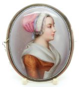 A white metal brooch set with a painted porcelain plaque of a Dutch girl, 6.8 x 5.