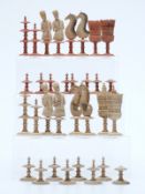 An 18thC German figural bone chess set with turned and carved pieces, one side stained red,