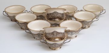 A set of twelve Lennox porcelain soup bowls set in twin handled pierced Art Nouveau sterling silver