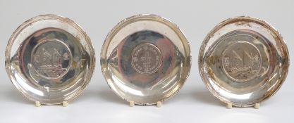 Three white metal coin based pin trays each marked sterling, diameter 9cm,