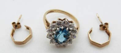 A 9ct gold ring set with a blue topaz and paste and a pair of yellow metal earrings