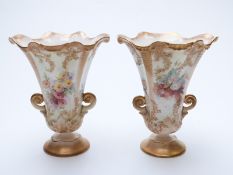 A pair of Royal Doulton pedestal faience vases with crimped rims and hand decoration of flowers,