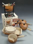 A collection of Le Creuset including graduated set of three pans, large dish,