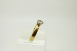 An 18ct gold ring set with a round cut diamond of approximately 0.