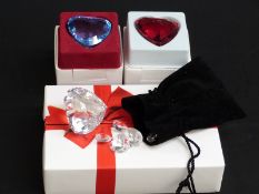 Four Swarovski Crystal cut glass heart shaped paperweights, largest 8cm tall, in original boxes,