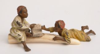 Austrian cold painted bronze model of two children on an elephant tusk reading a book,