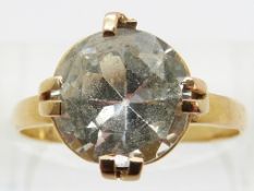 A yellow metal ring set with a large round cut white sapphire, approx 3ct,