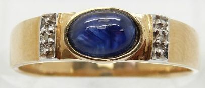 A 14ct gold ring set with a sapphire cabochon and diamonds to the shoulders,