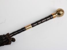 A late 19thC/20thC parasol with yellow metal handle and collar on bamboo stick,