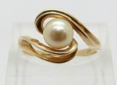 A 14k gold ring set with a pearl in a twist setting,