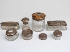 Seven various hallmarked silver lidded dressing table pots and a further silver lid