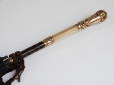 A late 19thC/20thC parasol with mother-of-pearl and yellow metal repoussé decorated handle with