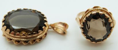 A yellow metal ring set with a round cut smoky quartz and a matching pendant, 16.