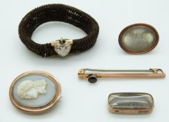 A mourning bracelet made up of plaited hair and a gold fitting set with green enamel and seed