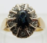 An 18ct gold ring set with a sapphire surrounded by diamonds,