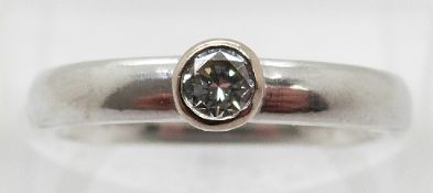 A platinum ring set with a round brilliant cut diamond of approximately 0.