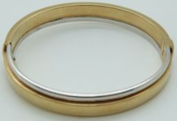 A 9ct bi-coloured gold bangle, 13.