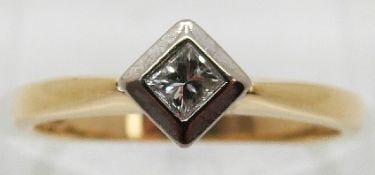 An 18ct gold ring set with a princess cut diamond in a platinum setting,