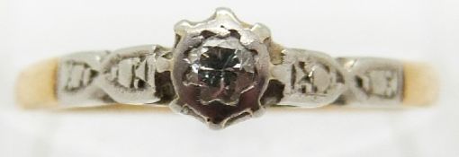 An 18ct gold ring set with a diamond in a platinum setting,