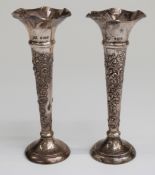 A pair of Edward VII hallmarked silver trumpet vases with embossed decoration,