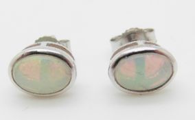 A pair of 9ct white gold earrings set with an opal cabochon to each