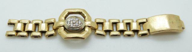 An 18ct gold ring in a strap design set with an oval panel of diamonds, 10.