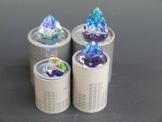 Four Swarovski Crystal cut glass coloured paperweights, largest 8cm tall,