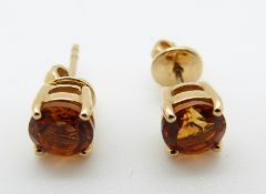 A pair of 18ct gold earrings set with a round cut citrine to each