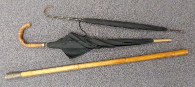 A white metal topped walking cane and two umbrellas / parasols