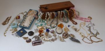 A collection of costume jewellery including beads, brooches, lucite brooch, cameo brooch,