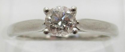 A platinum ring set with a round brilliant cut diamond of approximately 0.