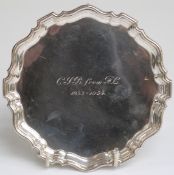 Hallmarked silver card tray with shaped edge, raised on three scroll feet,