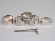 Five various hallmarked silver napkin rings and a pusher,