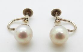 A pair of 9ct white gold earrings set with a pearl to each,
