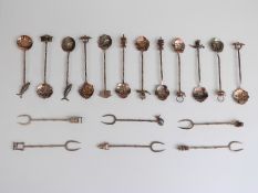 A set of 12 Eastern white metal spoons decorated with articulated fish, pagodas etc,