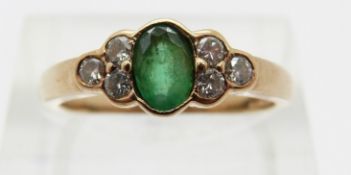 A 9ct gold ring set with an oval emerald and six diamonds,