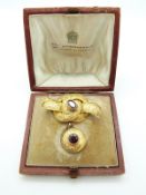Victorian yellow metal knot brooch set with garnets, with chased decoration all over,