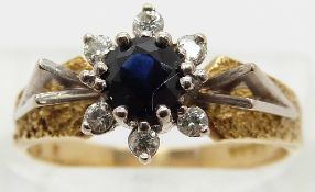 An 18ct gold ring set with a sapphire surrounded by diamonds with triangular shoulders,