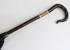 A late 19thC/20thC parasol with horn handle in the form of a crook,