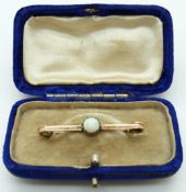 A 9ct gold opal bar brooch set with a circular opal cabochon, 2.25g, L3.