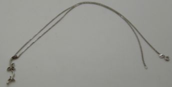 A platinum pendant set with a diamond in a floral design, 2.4g and a 9ct white gold chain, 2.