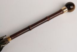 A 19thC parasol with spherical tiger's eye handle and two yellow metal mounts/collars, 89cm,