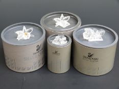 Four Swarovski Crystal cut glass flower paperweights, largest 8cm long,