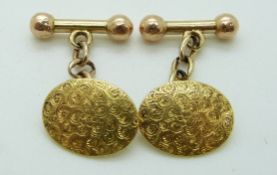 A pair of yellow metal cufflinks with engraved decoration, 7.