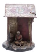 Franz Bergmann style figure of an ivory poacher smoking a pipe with tusks and guns beneath a