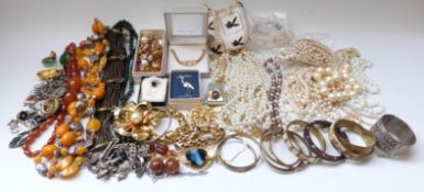 A collection of costume jewellery including faux pearls, amber style jewellery, bangles,