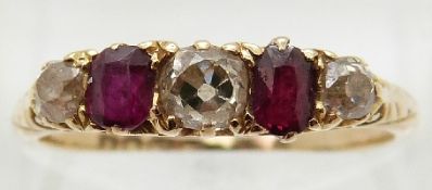 An 18ct gold Edwardian ring set with three old mine cut diamonds and two rubies,