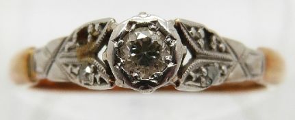 An 18ct gold ring set with a diamond in a platinum setting,