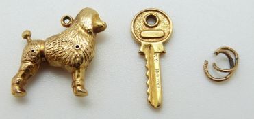 A 9ct gold charm in the form of a poodle and a 9ct gold charm in the form of a key, Chester 1957,