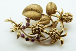 A 9ct gold brooch in a foliate design set with rubies, in Mappin & Webb box, 7.9g, L4.3cm, W2.